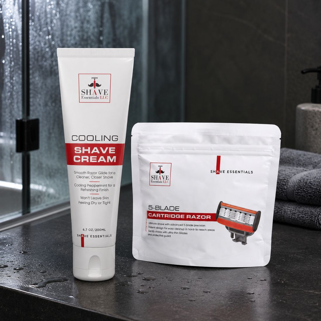 Shave Essentials Cooling Shave Cream tube and 5-Blade Cartridge Razor in white packaging, displayed on a dark bathroom counter next to a shower door and folded towels.