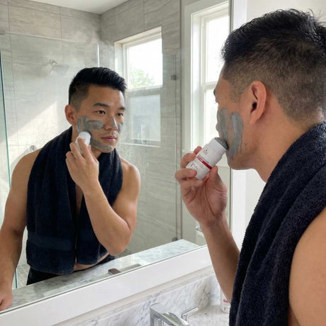 Man applying facial mask in front of a mirror | Shave Essentials