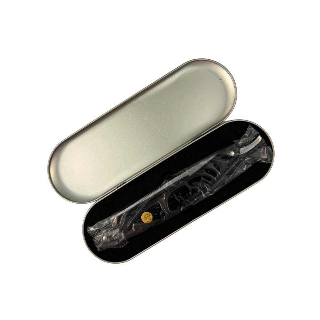 Oval-shaped metal case with a Medallion Razor inside on a white background | Shave Essentials